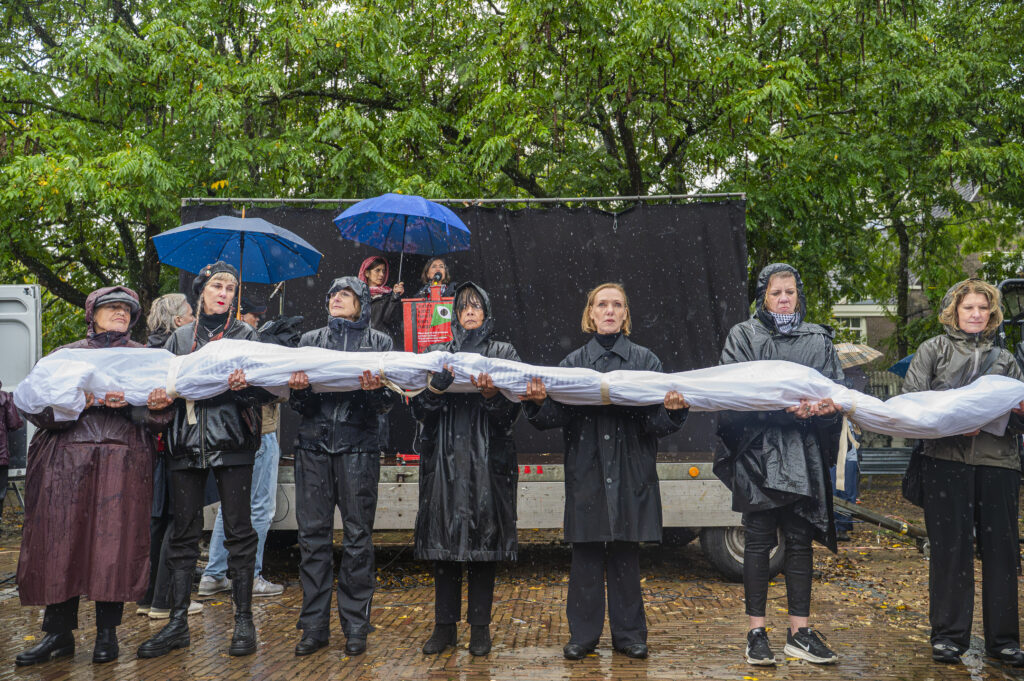 Een regenachtige start van de stille herdenkingstocht op het Amstelveld in Amsterdam. Foto: Harrie van Veen